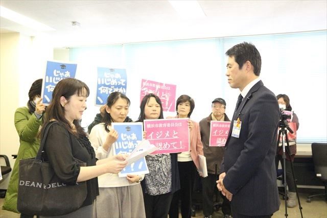 ▲共同代表の沼田美紀さん（左）から要望書を受け取る横浜市教育委員会の総務課担当者（右）